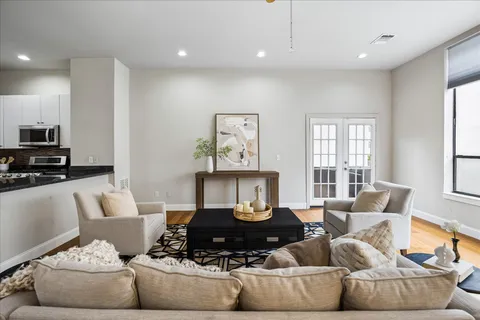 a living room with furniture and a wooden floor