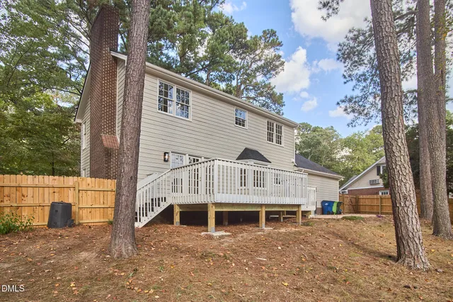 an aerial view of a house with a yard and large trees