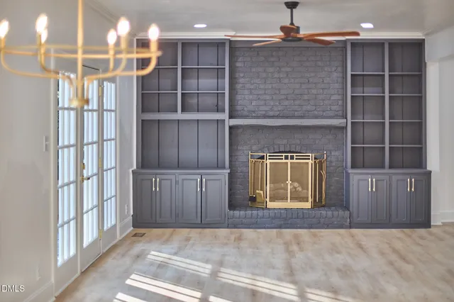 a view of an empty room with a fireplace and a window