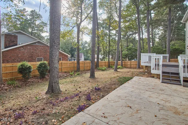 an aerial view of residential house with outdoor space and trees all around