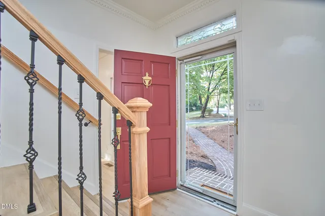 a view of entryway bedroom and hall with wooden floor