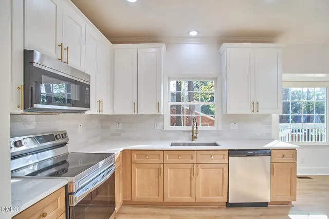 a large kitchen with kitchen island a large window and a chandelier