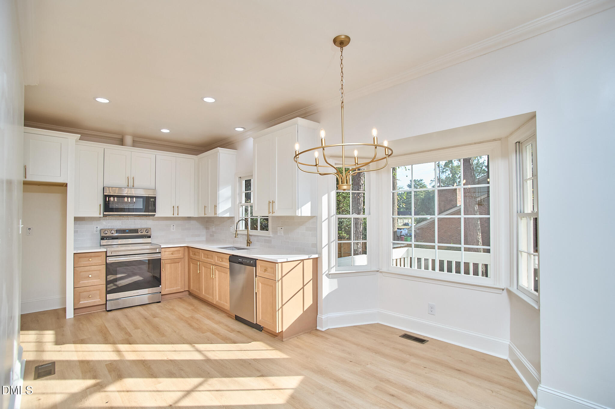 5721 Timber Ridge Drive Raleigh, NC 27609 - Photo 7 of 76 a large kitchen with kitchen island a large window and a chandelier