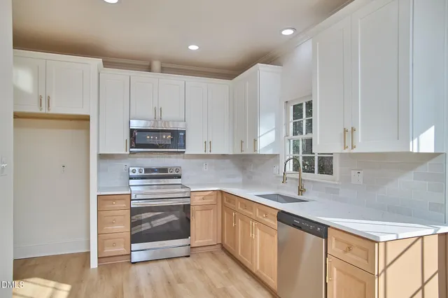 a kitchen with stainless steel appliances granite countertop a sink a window and a refrigerator