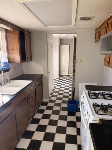 a kitchen with a sink a stove and a cabinets