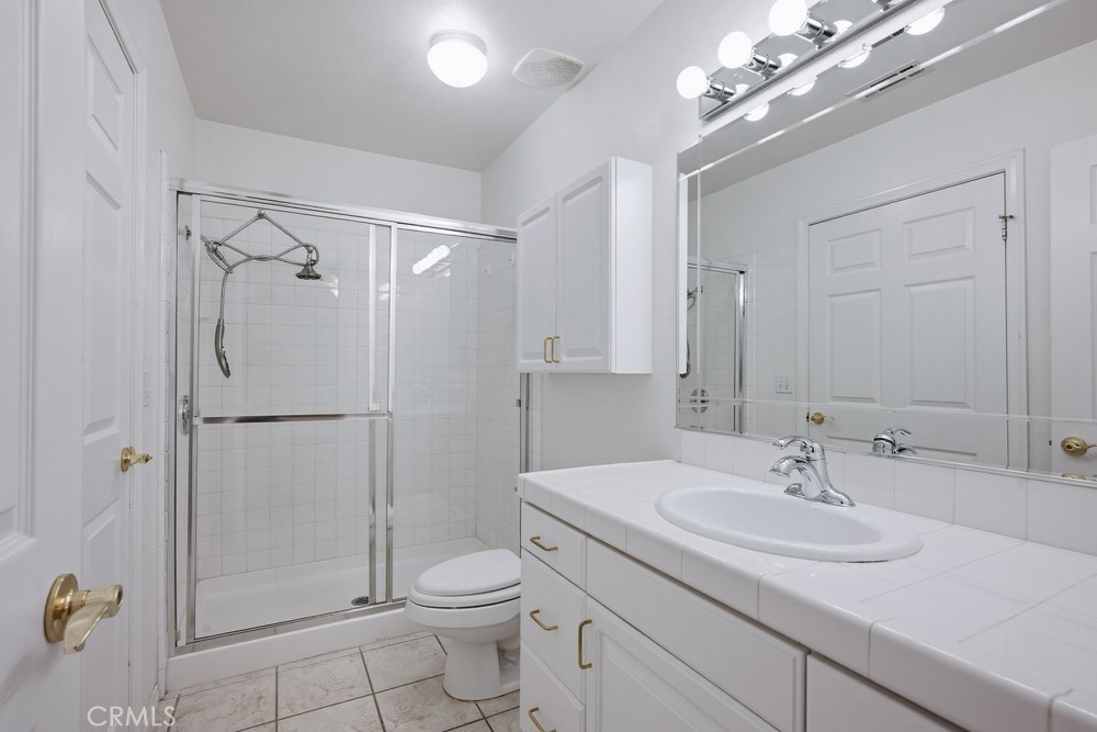 2998 Elder Way Hemet, CA 92545 - Photo 11 of 28 a bathroom with a granite countertop sink a toilet and shower