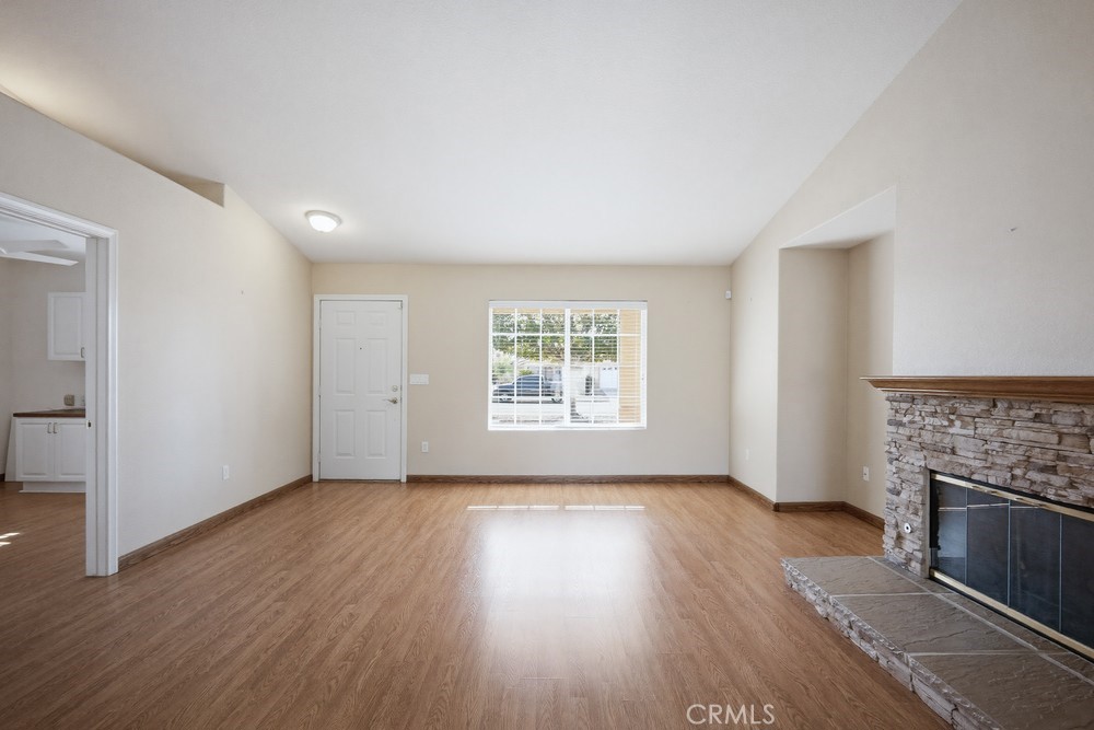 2998 Elder Way Hemet, CA 92545 - Photo 6 of 28 an empty room with wooden floor fireplace and windows