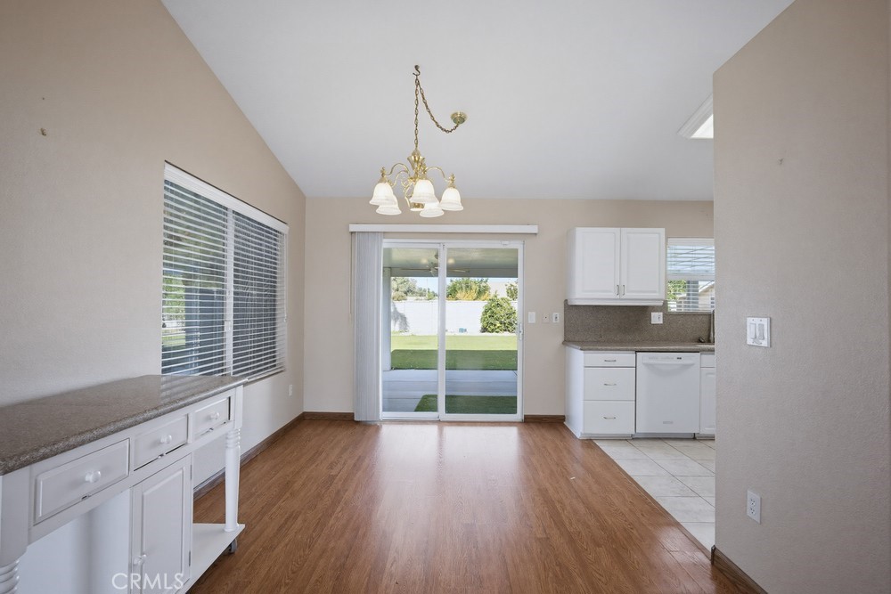 2998 Elder Way Hemet, CA 92545 - Photo 8 of 28 a open kitchen with granite countertop a stove top oven a sink dishwasher and white cabinets with wooden floor next to windows