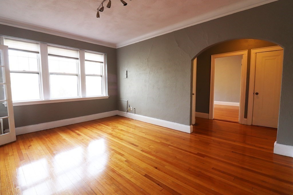 8 Chiswick Road, Unit 36 Boston, MA 02135 - Photo 7 of 16 an empty room with wooden floor and windows