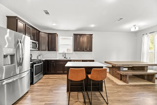 a kitchen with stainless steel appliances granite countertop a stove refrigerator sink and cabinets