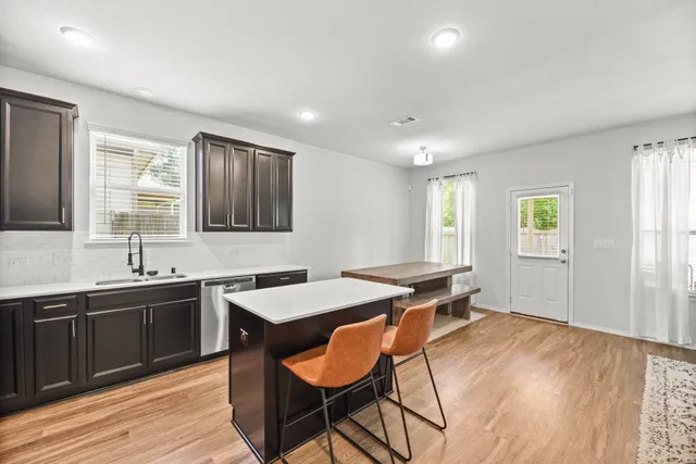 a kitchen with a sink cabinets and wooden floor