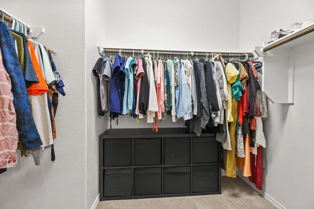 a view of walk in closet with clothes