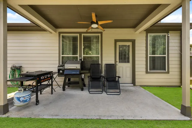 a backyard of a house with barbeque oven table and chairs