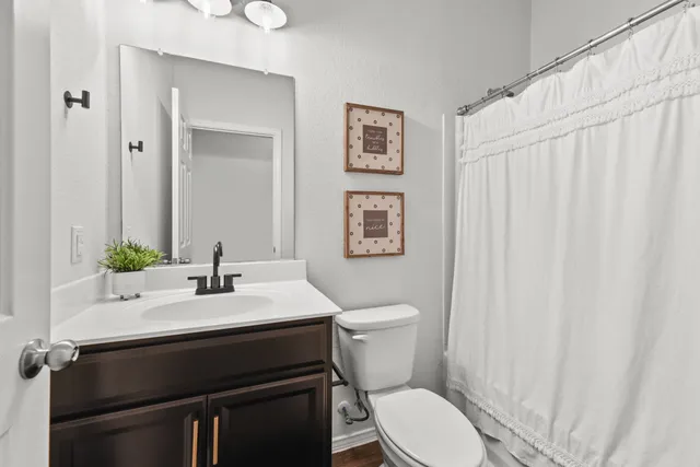 a bathroom with a sink a toilet and a mirror
