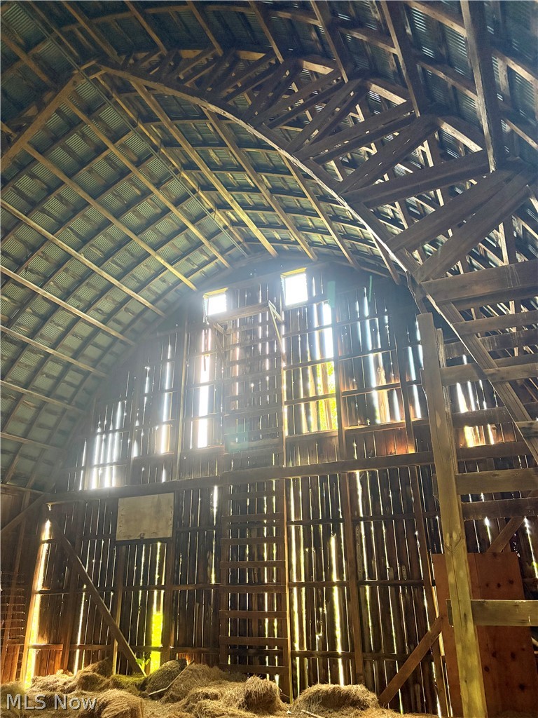 7251 Ryan Road Medina, OH 44256 - Photo 30 of 47 Architectural barn interior featuring a vaulted wood-beam ceiling, corrugated metal roofing, and multiple upper-level window openings
