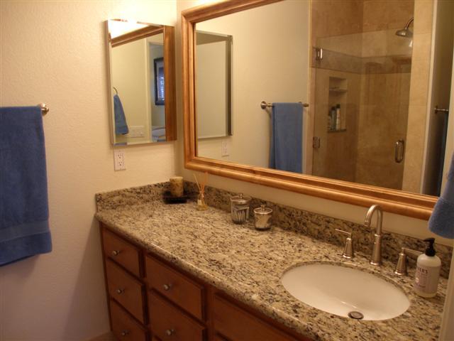 3566 Modoc Road, Unit 36 Santa Barbara, CA 93105 - Photo 16 of 18 a bathroom with a granite countertop sink and a mirror