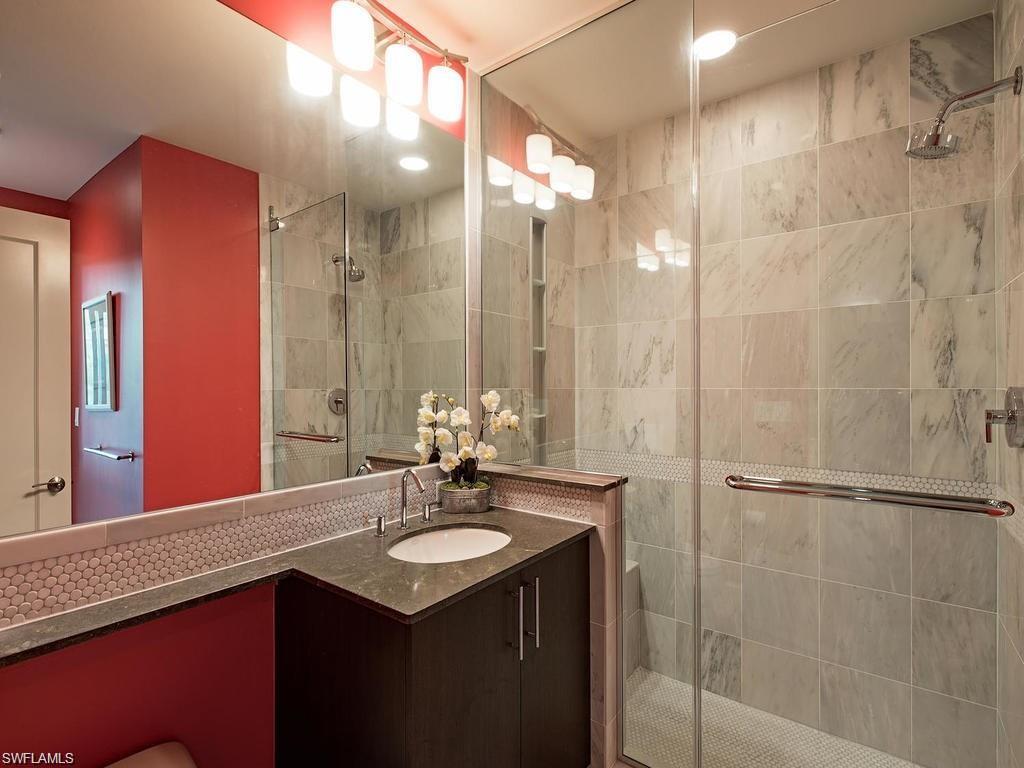 9123 Strada Place, Unit 7306 Naples, FL 34108 - Photo 4 of 19 a bathroom with a sink vanity granite shower and a mirror