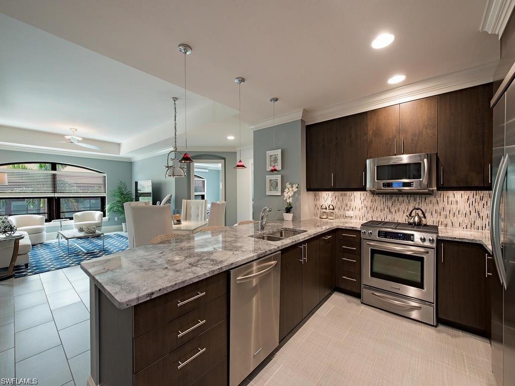 9123 Strada Place, Unit 7306 Naples, FL 34108 - Photo 5 of 19 a kitchen with a sink stove and microwave