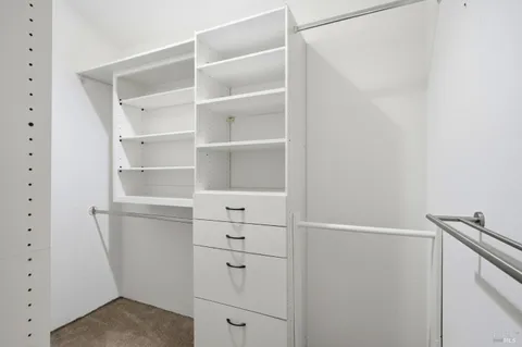 a view of walk in closet with empty racks
