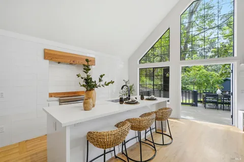 a dining room with furniture and large windows