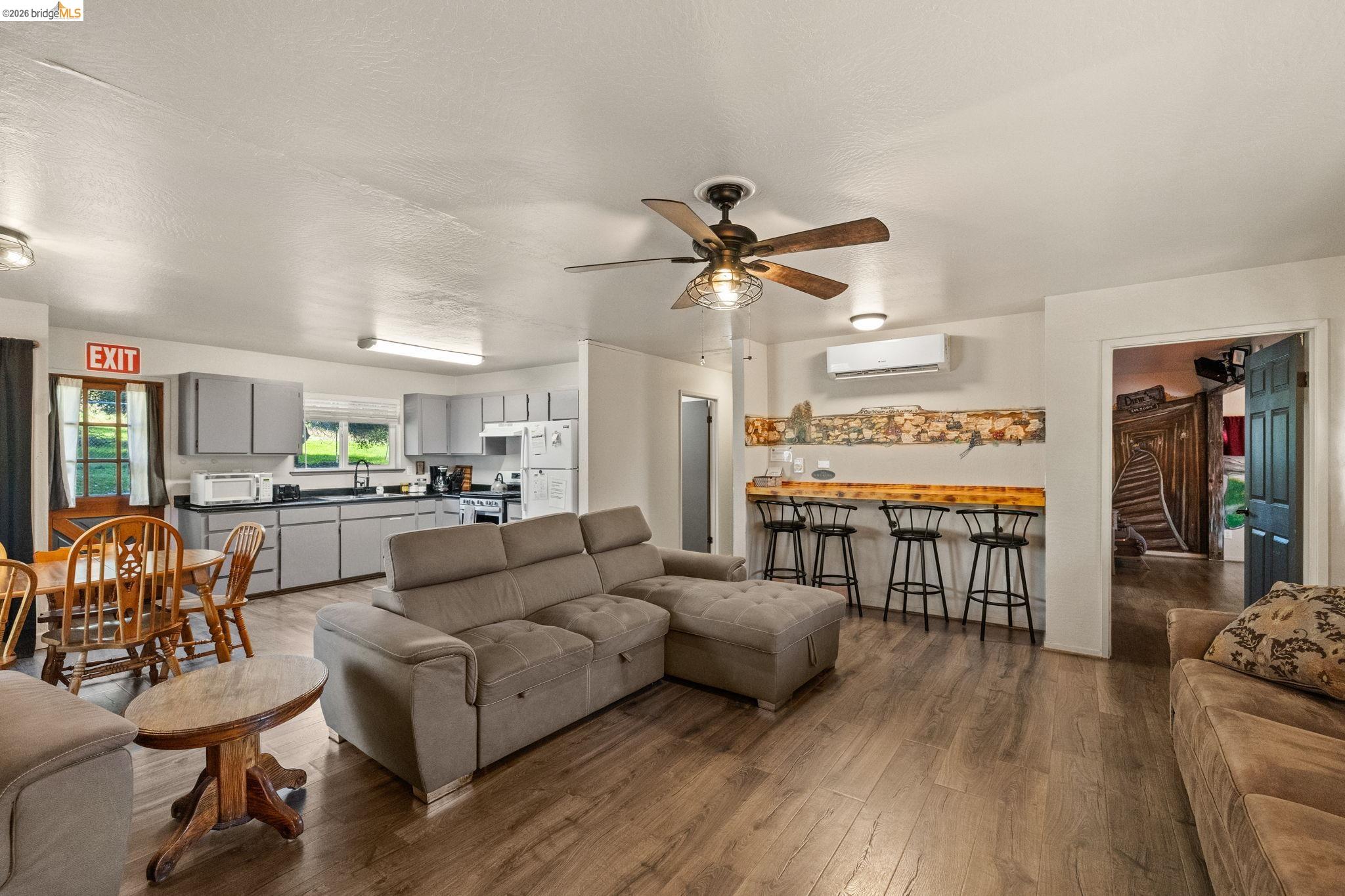 22941 Hudson Road Columbia, CA 95310 - Photo 12 of 34 a living room with furniture kitchen area and a wooden floor
