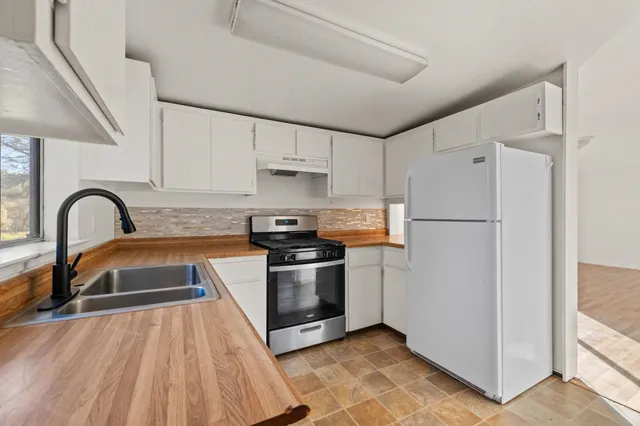 a kitchen with granite countertop a refrigerator and a sink