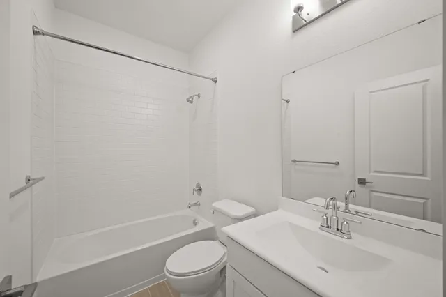 a bathroom with a bathtub shower sink vanity mirror and toilet