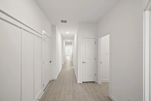 a view of a hallway with wooden floor