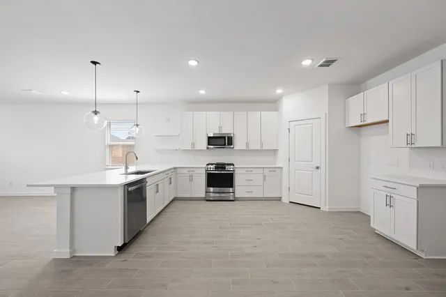 a large kitchen with cabinets and stainless steel appliances