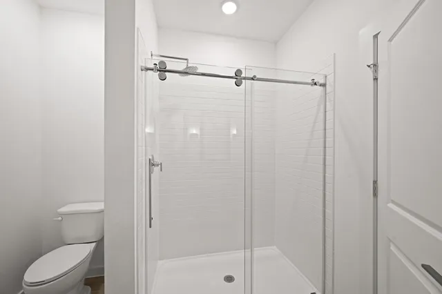 a bathroom with a shower a toilet and a shower