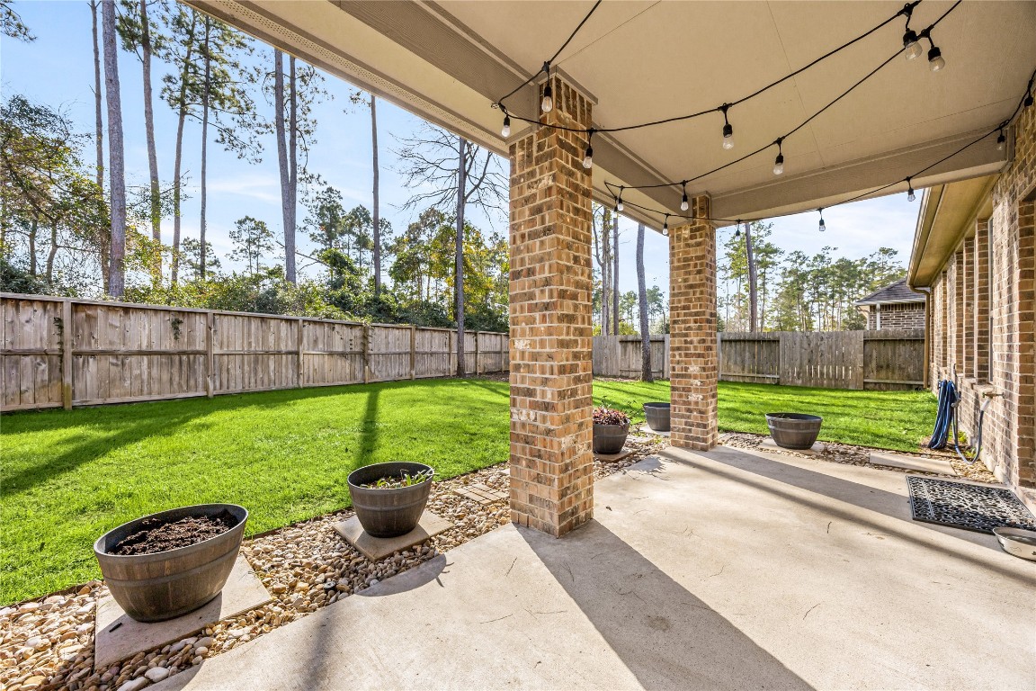 14023 Beaverhead Range Court Conroe, TX 77384 - Photo 22 of 29 Step outside to your private outdoor oasis! This beautifully designed covered patio and spacious backyard provide the perfect retreat for relaxation, entertaining, or simply enjoying the beautiful weather.