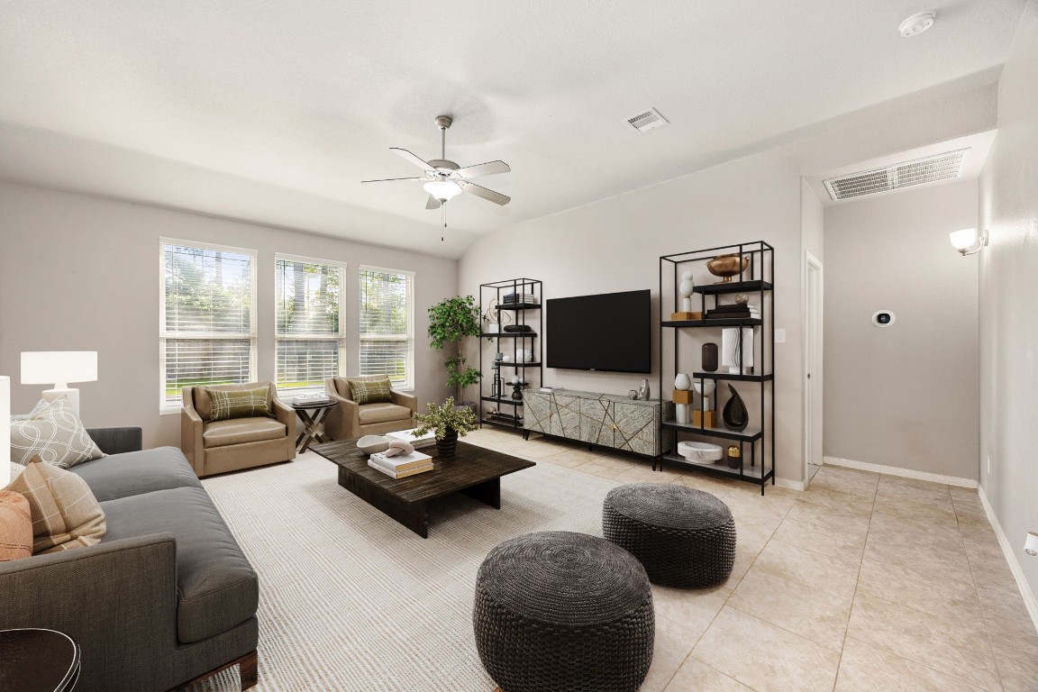 14023 Beaverhead Range Court Conroe, TX 77384 - Photo 6 of 29 This bright and airy living room features tile flooring, neutral toned walls, vaulted ceilings with ceiling fan, and large windows with fitted blinds allowing abundant natural lighting and gorgeous outdoor views. *Virtually Staged