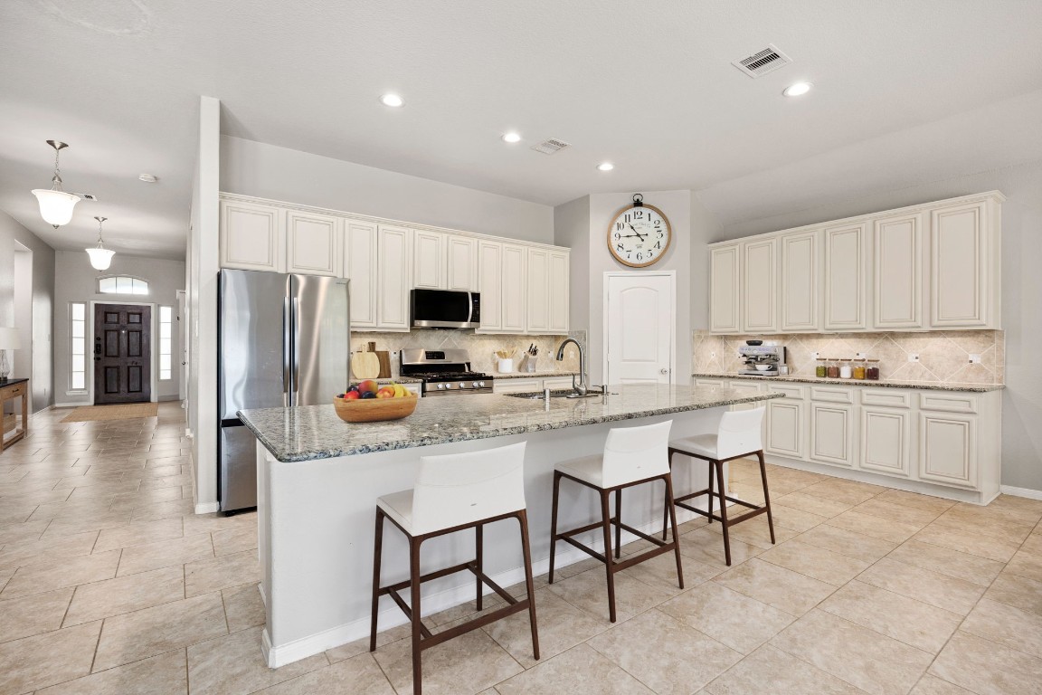 14023 Beaverhead Range Court Conroe, TX 77384 - Photo 8 of 29 The heart of the home is this expansive kitchen island, designed as the ultimate gathering spot for casual meals, homework, or social entertaining. Featuring elegant granite countertops, this oversized island offers ample prep space, a convenient undermount sink, and comfortable seating. It serves as a striking visual centerpiece, seamlessly integrating the kitchen into the open-concept living area and ensuring conversations flow easily between spaces. *Virtually Staged