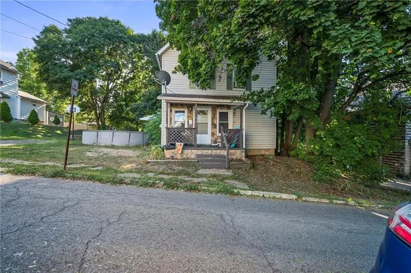 a view of a house with a yard and large tree