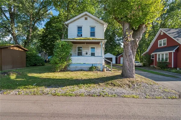 a view of a yard in front of a house with a large tree