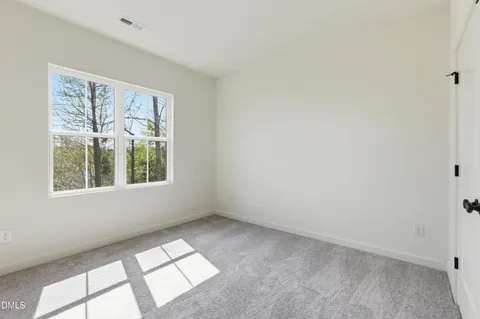 a living room with furniture potted plant and white walls