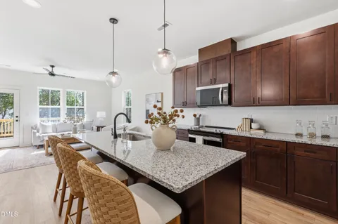 a kitchen with kitchen island granite countertop a sink counter and chairs
