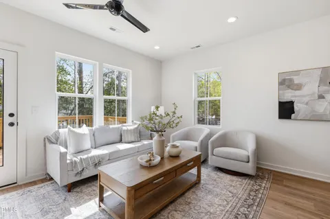 a living room with furniture kitchen view and a chandelier