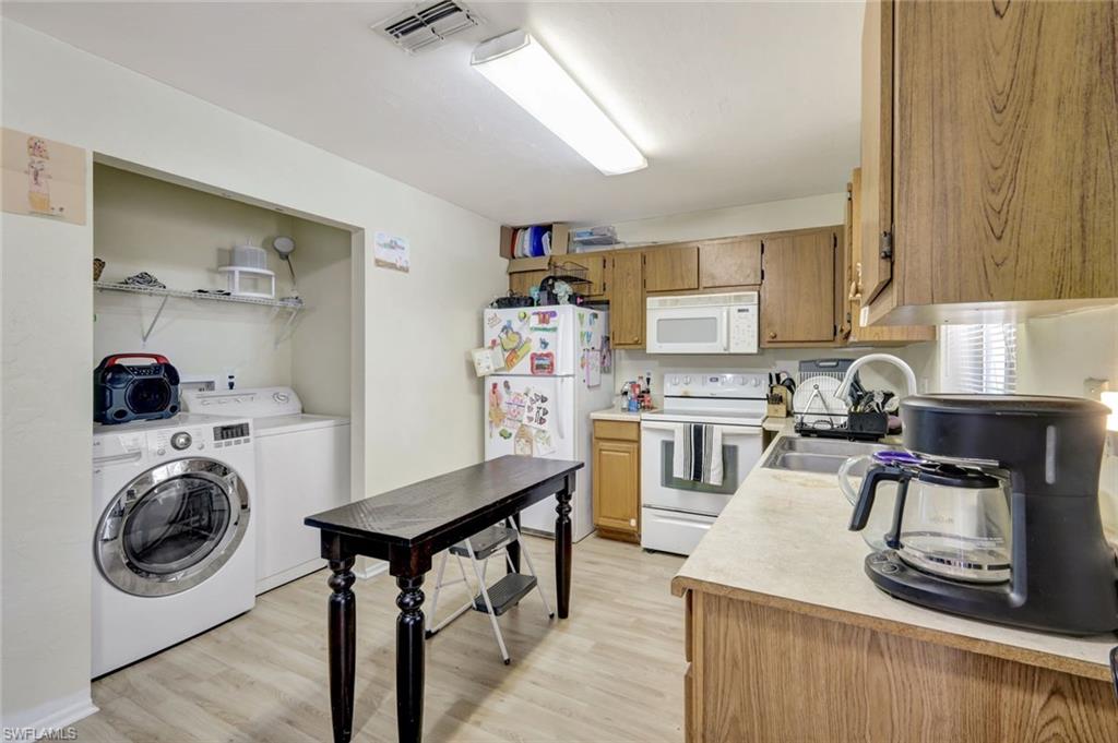 7481-7485 Pebble Beach Road Fort Myers, FL 33967 - Photo 22 of 31 a kitchen with stainless steel appliances granite countertop a sink stove and refrigerator