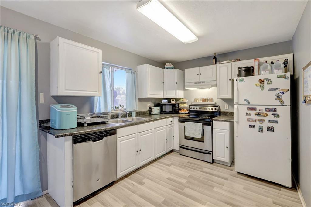 7481-7485 Pebble Beach Road Fort Myers, FL 33967 - Photo 7 of 31 a kitchen with granite countertop white cabinets and white appliances