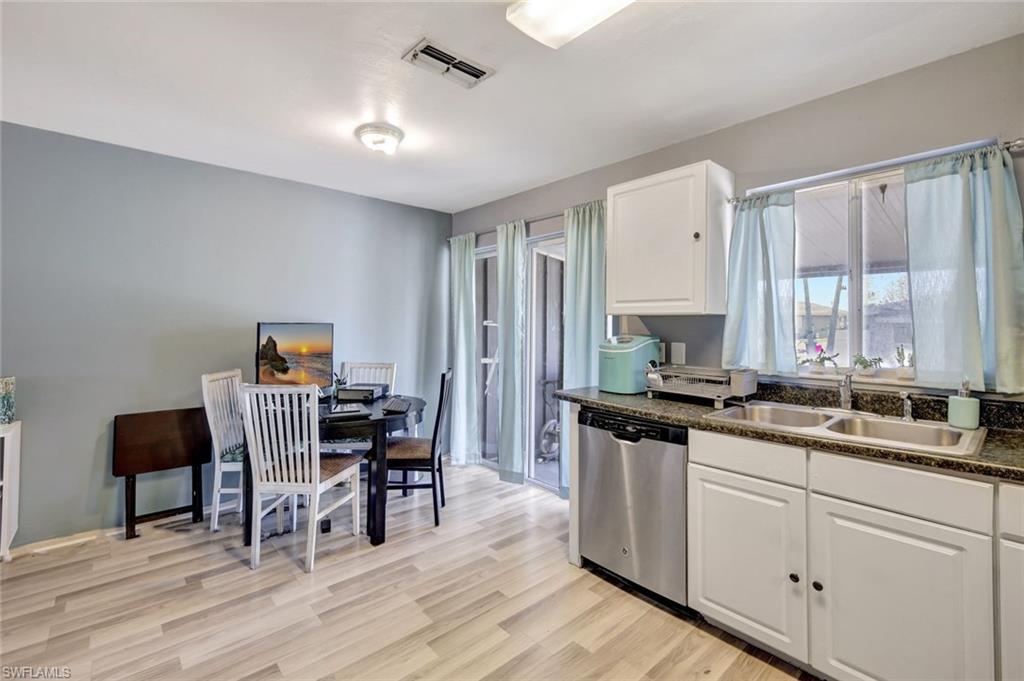7481-7485 Pebble Beach Road Fort Myers, FL 33967 - Photo 10 of 31 a kitchen that has a lot of cabinets in it and wooden floors