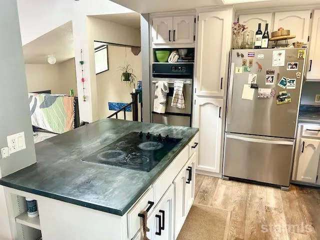 a kitchen with stainless steel appliances granite countertop a refrigerator a stove and a sink