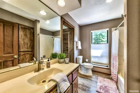 a bathroom with a tub sink and mirror
