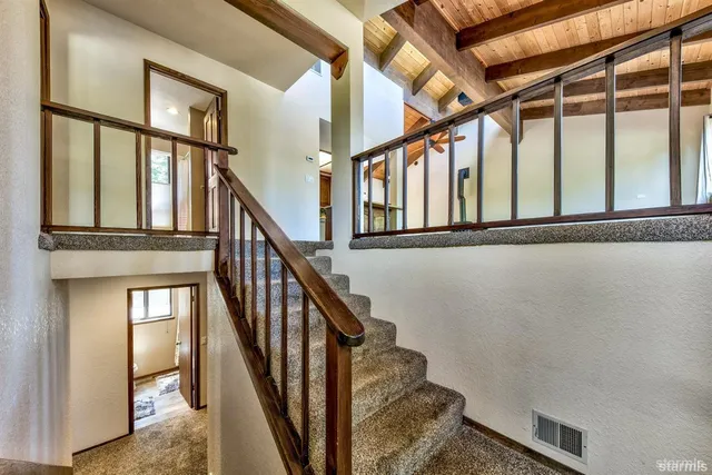 a view of staircase with lots of frames on wall and a window