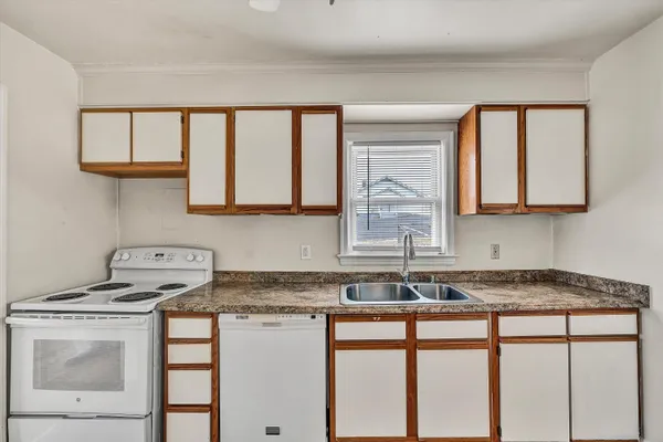 a kitchen with granite countertop a sink and a stove