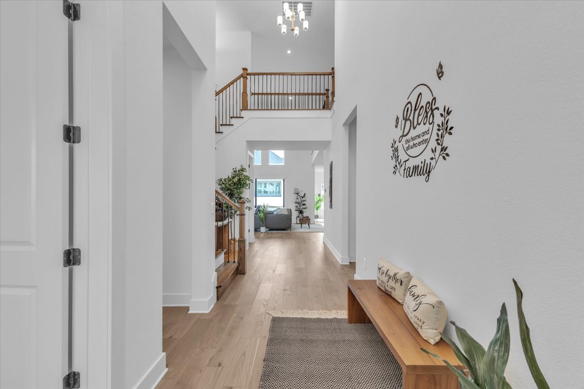 2312 Mondello Path Leander, TX 78641 - Photo 6 of 40 Hall with a high ceiling, light wood finished floors, and hanging lights