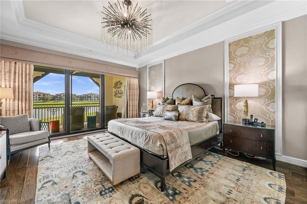 16436 Carrara Way, Unit 102 Naples, FL 34110 - Photo 18 of 43 Bedroom featuring hardwood / wood-style flooring, a raised ceiling, access to outside, a water view, and ornamental molding