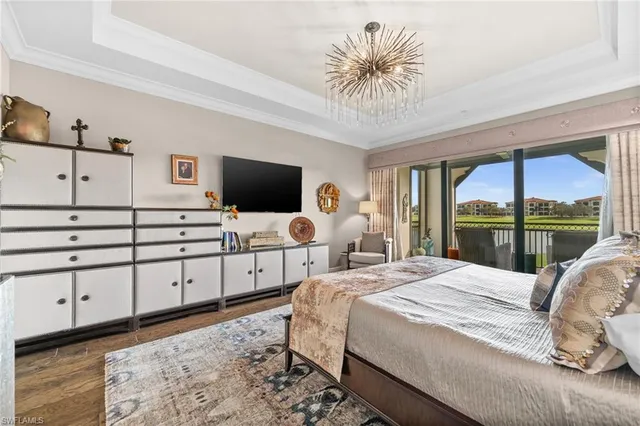 a bedroom with a large bed and a flat tv screen on dresser