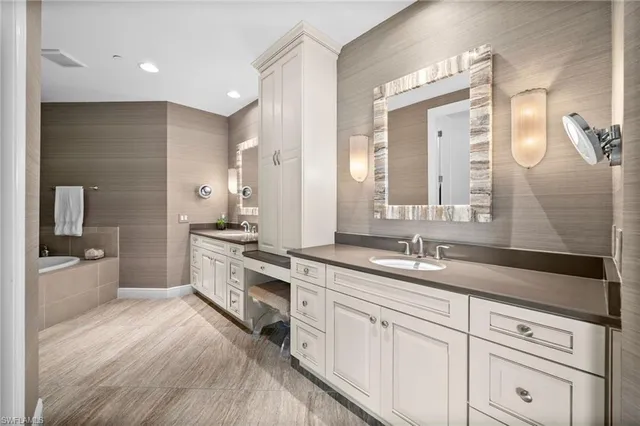 a spacious bathroom with a double vanity sink a mirror and a