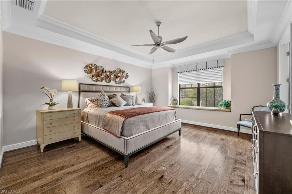 16436 Carrara Way, Unit 102 Naples, FL 34110 - Photo 23 of 43 Bedroom with a raised ceiling, crown molding, wood-type flooring, and ceiling fan